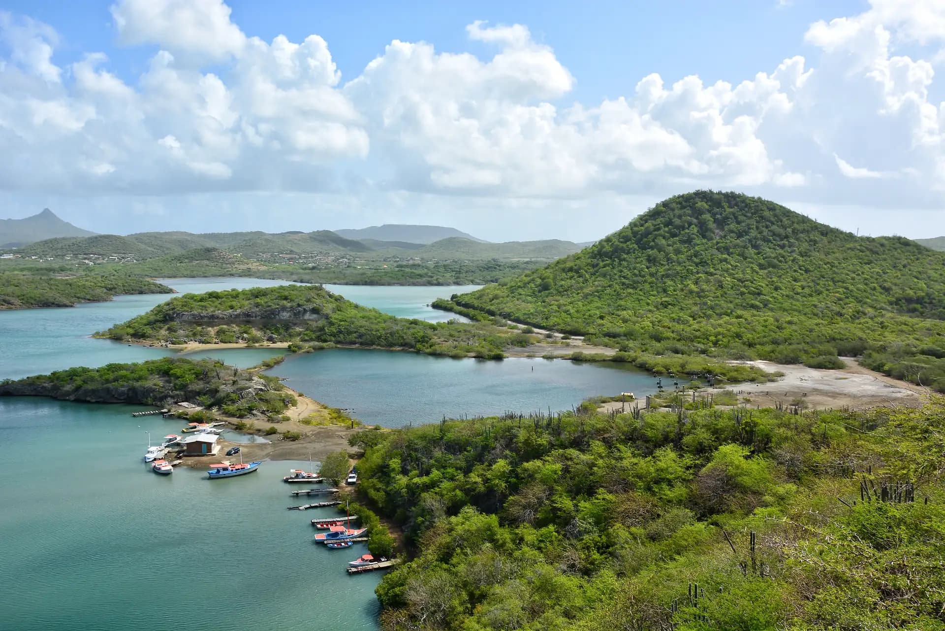 Santa Martha Bay seen from the hills, small boats moored below green slopes, Curaçao